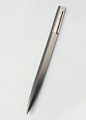 BVLGARI – Eccentric ballpoint pen. Brushed metal body in triangular profile. Clip integrated with asymmetric twist cap. Circa 2000s.