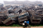 A woman rides past old fishing boats on her motorcycle in Qingdao city, Shandong province, China, May 14, 2012. Reports state that excessive fishing, ocean pollution and the high price of diesel have caused a sharp decline in fishery resources, nearly par