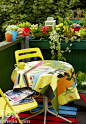 阳台是就餐区的一种延伸，将室外的绿意和自己的盆栽融合成一道风景，铺上红蓝宽条纹的地毯，放上亮丽的黄色座椅，用一块大花案的桌布进行最后的点睛，时时刻刻享受着生活带来的美好惬意。
