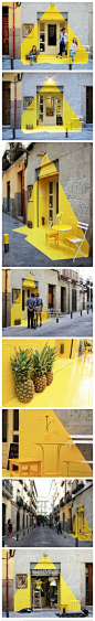 #创意在线#“凝固的光束”餐饮。(fos) 是一个跨界工作室，其首个作品是在马德里一家素食餐厅的店门口制作了一个短期装置，使用黄色胶带、装饰画、几只菠萝和店门口一盏灯创造了灯点亮后的效果让路人纷纷驻足欣赏。非常有创意.