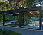 Glass House in the Garden : Modern glass house set in the landscape evokes a midcentury vibe. A modern gas fireplace divides the living area with a polished concrete floor from the greenhouse with a gravel floor. The frame is