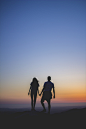 man and woman holding hands in silhouette photography