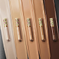 A close up shows four different shades of Gucci Concentré De Beauté in a row – each displaying a floral patterned cap. Each lies on a streak of their shade colour going from the lightest to the darkest.