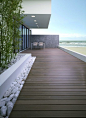 Simple but beautiful dark decking contrasting with white beach pebbles.: 