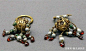 此展品为唐代金属器，耳坠穿环与坠饰相衔接处镶2粒珍珠，坠饰镂成空心花球状，底部垂挂宝石一串。现收藏于扬州博物馆。
