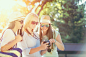 Three attractive girls looking at photos on their camera at summer holidays, girl friends on... by Andrea Obzerova on 500px