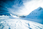 A frozen landscape with mountains coated with a thick layer of snow