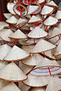 Souvenir conical hats. Hanoi, Vietnam. This style of hat is used as protection from the sun and rain. When made of straw or matting, it can be dipped in water and worn as a cooling protection.