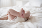 Legs of Caucasian baby girl laying on bed by Gable Denims on 500px