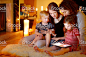 Happy family using tablet pc by a fireplace 免版稅 stock photo