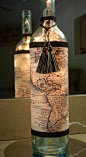 Recycled wine bottle lamp covered with vintage world map and tassle trim