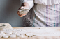 Two hands making dough for meat dumplings.