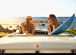 Women relaxing in convertible on beach - stock photo