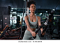 Fit young African American female athlete in sportswear exercise bodybuilder pulling down wire cable on gym equipment in fitness center.Workout for good health concept.