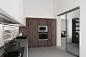 【厨房】：白色橱柜简约大方，配以内置壁灯，更显简洁敞亮。侧边棕色木墙装饰，并设计内嵌烤箱，实用而美观。
