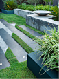 Montis Garden : A cool contemporary makeover of this back garden. Angled gardens with an angled overlay of granite paving give this garden the illusion that it is not just a rectangular space. The recesses in the