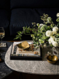 Marble coffee tables and brass accents make the space feel like a curated home.