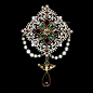 This enamelled gold brooch is set with a brilliant-cut diamond, garnets, emeralds, rubies and an amethyst drop and hung with green glass beads and pearls. This is the perfect example of the ornate style which was in vogue in the mid-Ninetee