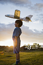 USA, Colorado, Boy (6-7) playing with model airplane outdoors_创意图片