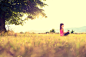 Young athletic woman practicing yoga on a meadow at sunset, image with lens flare - stock photo