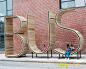 在巴尔的摩市中心，西班牙艺术家团体mmmm…创作了一座14英尺高的永久性公共艺术休闲景观雕塑，这是一个公共汽车站，该雕塑由公共汽车的英文单词BUS的三个字母组成。作为初始换乘站的一部分，这个字体雕塑如今已经成为一处为人们提供社交对话和活动的公共场所，雕塑的每个字母有7英尺多宽，这座城市装置主要是由木头和金属道具制作而制成，大量的木板被装在金属的构架里，这样可以使该装置能够承受额外的重量，也能防止故意破坏。