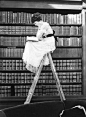 Lady on a ladder in a library.