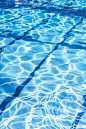 游泳池里的涟漪水，反射着阳光。夏天在游泳池。背景和纹理概念。垂直。