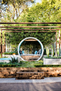 This award winning garden design uses concrete pipes to create seating, a water feature, and a fire pit.: