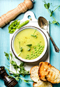 Light summer green pea cream soup in bowl with sprouts, bread toasts and spices by Anna Ivanova on 500px