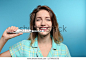 Portrait of young woman with electric toothbrush on color background