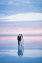 美国一对夫妇在犹他州邦纳维尔盐碱滩，拍摄的一组非常惊人、浪漫的婚纱照。浅浅的湖水如一面镜子，映射着天空、白云、晚霞。。。水天共融，画面美到不敢相信！