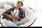 handsome guy with a dog sitting in a large armchair. photo with copy space Stock Photo