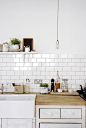 a kitchen / subway tiles, wood counters, industrial light