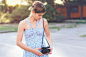 Smiling woman in dress using old camera.