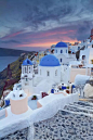 Oia, Santorini Island, Greece。希腊圣托里尼岛伊亚小镇。爱琴海最迷人的地方非圣托里尼岛莫属，它总是这样出现在诗句中：美丽的圣托里尼，有世界上最美的落日，最壮阔的海景；天地间蓝与白的相知相间，蓝得彻底，白得耀眼。而伊亚有着全世界最著名的日落、最漂亮的教堂、最迷人的白色小屋。走在伊亚，身上的每一个细胞都能感到，这里就是人间的天堂。当黄昏，游人便会纷至沓来，人满为患。因为在这里，才能欣赏到圣托里尼岛最著名的“日落爱琴海”的美景。