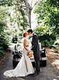 bride and groom kiss in front of their vintage car wedding transport