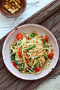 Green Papaya Salad in bowl ready to serve with peanuts, green beans, and tomatoes