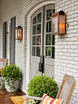 Love the double front door, pair of scones and boxwoods to frame the entry!