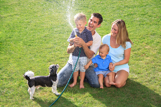 草地上玩水的一家人图片