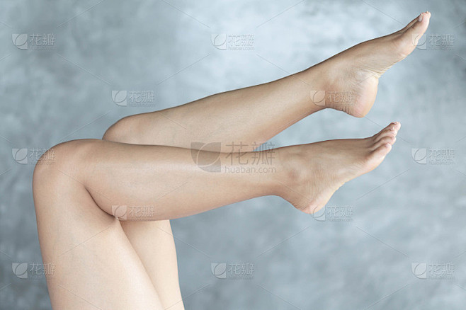 特写女人的腿放松与灰色的背景，美丽和皮肤...