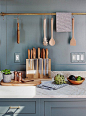 French blue cabinets and wall color pairs perfectly with marble, brass and copper kitchen accents.