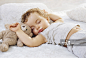 Sleeping toddler arms raised up with a Teddy bear