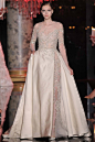 Elie Saab Fall 2014 Couture。不论是长袖公主礼服，还是鸡尾酒裙或者是更为干练的女士套装裙等，珍珠始终都贯穿其中，还可以起到调整整体比例的附带效果。幻般的花朵也是艾莉·萨博一直保持不变的特色，这一季的花朵元素也被赋予了色彩的魔法，在渐变的色彩主题下显得更有层次感，而那些花朵的立体刺绣工艺也更是令艾莉·萨博女裙充满了梦幻而高雅的奢华之风。