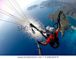 Paragliding in the sky. Paraglider tandem flying over the sea with blue water and mountains in bright sunny day. Aerial view of paraglider and Blue Lagoon in Oludeniz, Turkey. Extreme sport. Landscape