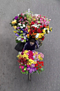 每天四点多起床，用自行车装满鲜花与水果，穿梭在城市里的各个角落，尽管能得到的金钱回报并不是很多，但也却是很多街头摊贩的重要收入之一！