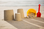 Bucket, spade and sand castles on beach Free Photo