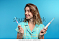 Young woman choosing between manual and electric toothbrushes on color background