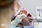 Over the shoulder view of dentist conducting dental examination on mature man