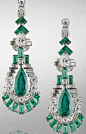 A fine pair of art deco emerald and diamond pendent earrings, circa 1920. Each articulated geometric surmount set with baguette-cut emeralds, brilliant, pear and baguette-cut diamonds, suspending a pear-shaped emerald swing drop, within a stepped surround