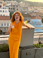 免费 穿着橙色衣服的女人在阳台上摆姿势 素材图片